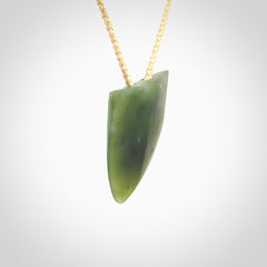 This is a lovely New Zealand Jade, pounamu niho drop pendant. It is bound with an adjustable beige coloured cord which is length adjustable.