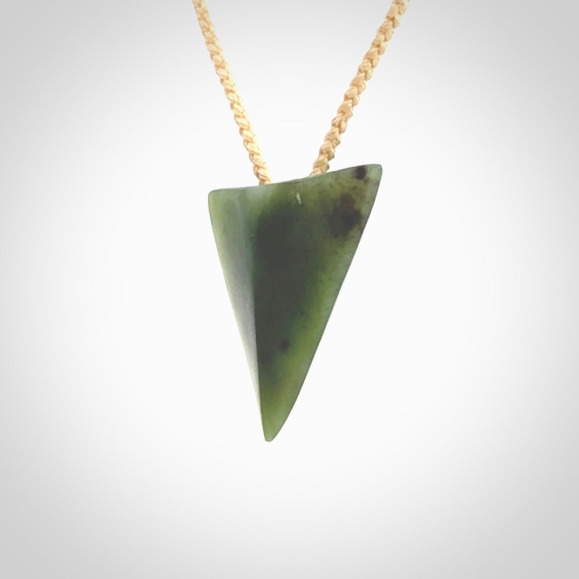 This is a lovely New Zealand Jade, pounamu niho drop pendant. It is bound with an adjustable beige coloured cord which is length adjustable.