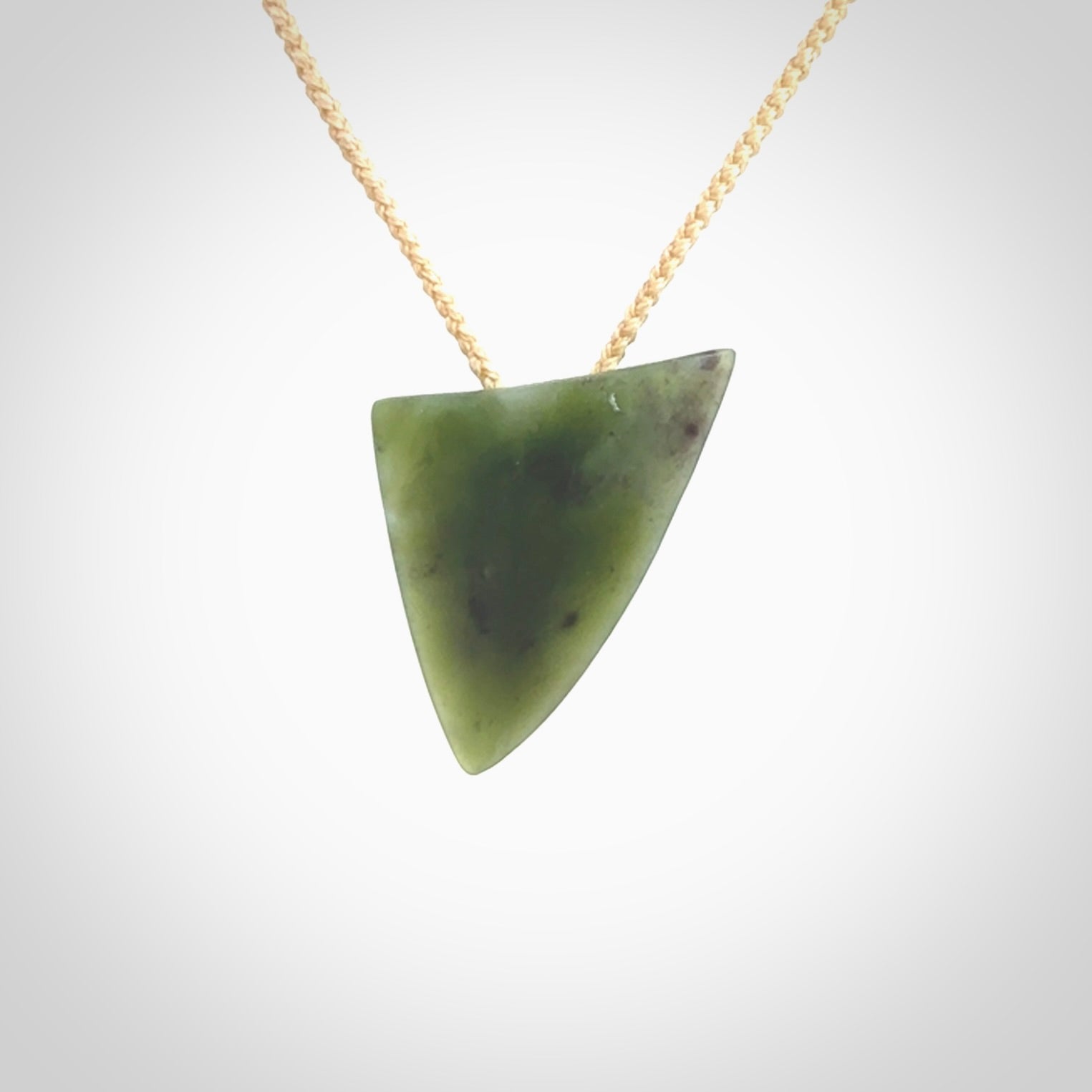 This is a lovely New Zealand Jade, pounamu niho drop pendant. It is bound with an adjustable beige coloured cord which is length adjustable.