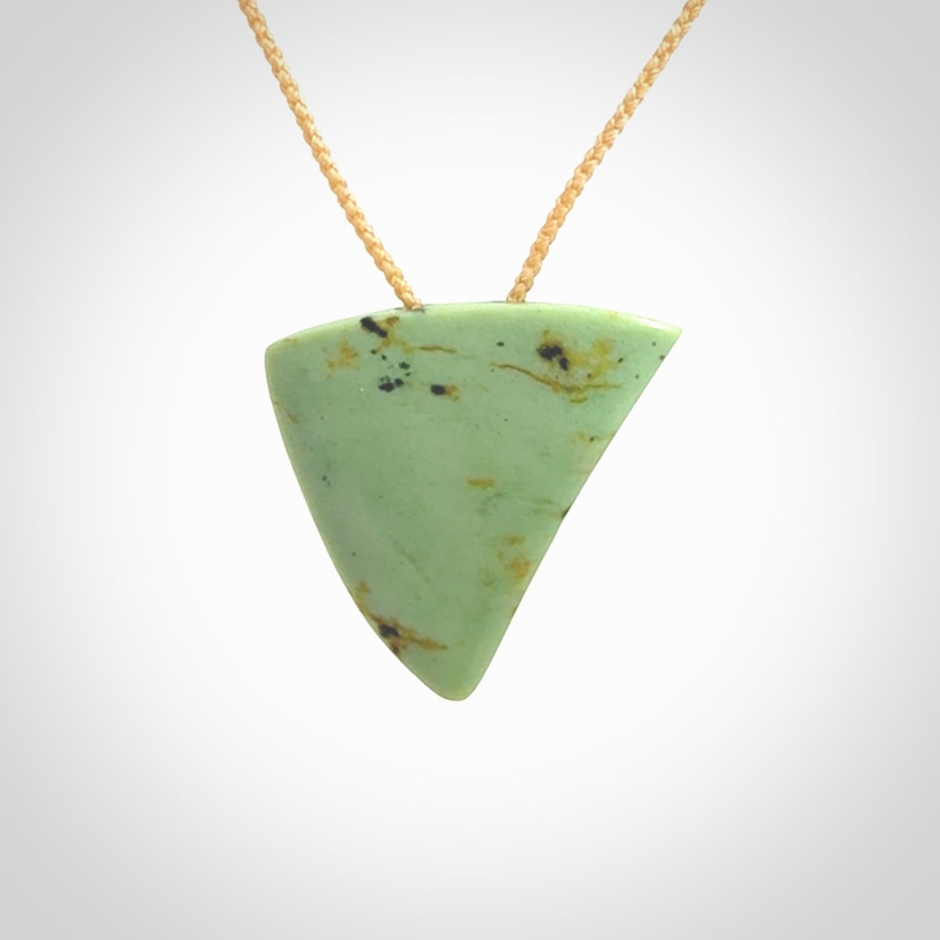 This is a lovely New Zealand Jade, pounamu niho drop pendant. It is bound with an adjustable beige coloured cord which is length adjustable.