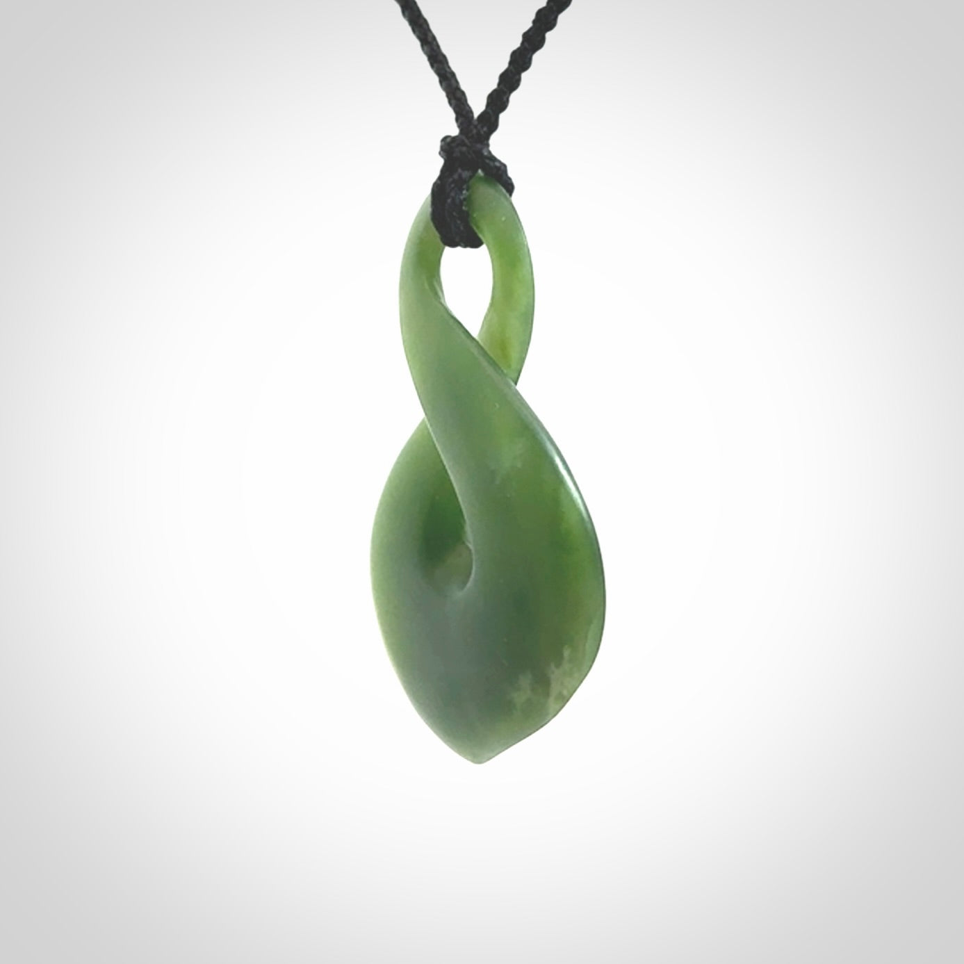 This piece is a fine, delicate drop shaped, single twist pendant. It was carved for us by Ric Moor from a lovely deep green piece of New Zealand jade. It is suspended on an black four plaited braided cord that is length adjustable.