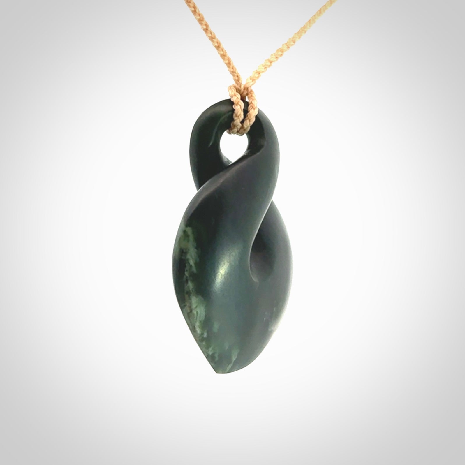This piece is a drop shaped, single twist pendant. It was carved for us by Ric Moor from a lovely deep green piece of New Zealand jade. It is suspended on an beige four plaited braided cord that is length adjustable.