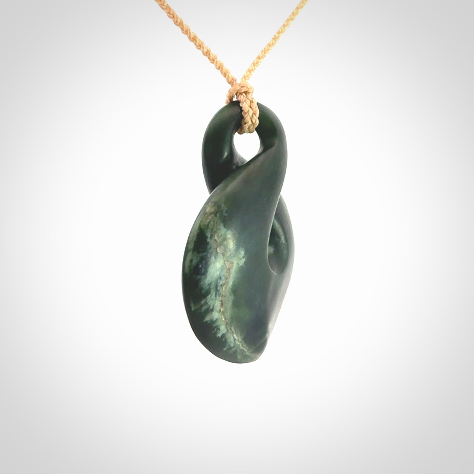 This piece is a drop shaped, single twist pendant. It was carved for us by Ric Moor from a lovely deep green piece of New Zealand jade. It is suspended on an beige four plaited braided cord that is length adjustable.