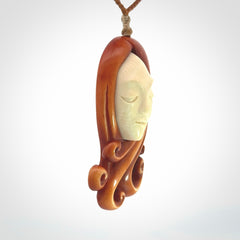 This is a hand carved bone contemporary female pendant. Yuri Terenyi has carved this from Stained Bone with Woolly Mammoth Tusk and Paua Shell inlay on the back of the pendant. It is a delightful, large and artistic piece of jewellery. One only necklace. The necklace is provided on an adjustable cord in a hand made, custom, wooden box.