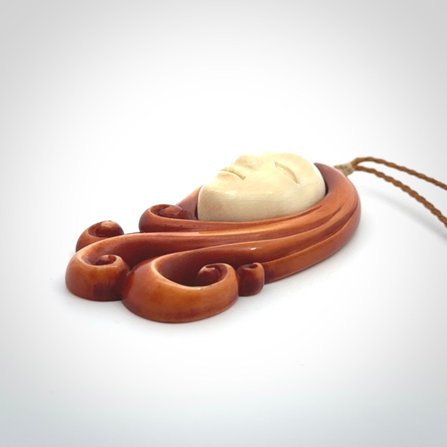 This is a hand carved bone contemporary female pendant. Yuri Terenyi has carved this from Stained Bone with Woolly Mammoth Tusk and Paua Shell inlay on the back of the pendant. It is a delightful, large and artistic piece of jewellery. One only necklace. The necklace is provided on an adjustable cord in a hand made, custom, wooden box.