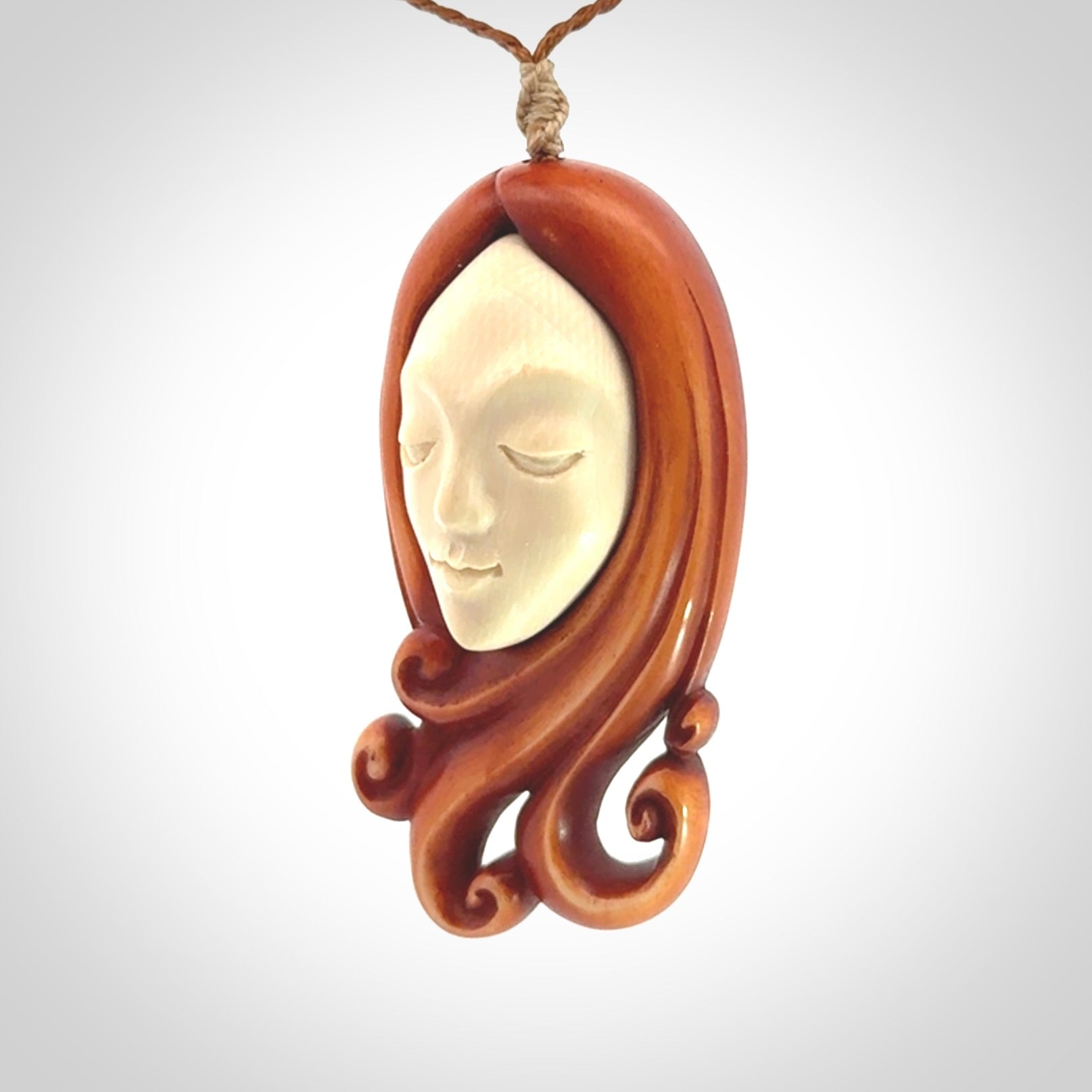 This is a hand carved bone contemporary female pendant. Yuri Terenyi has carved this from Stained Bone with Woolly Mammoth Tusk and Paua Shell inlay on the back of the pendant. It is a delightful, large and artistic piece of jewellery. One only necklace. The necklace is provided on an adjustable cord in a hand made, custom, wooden box.