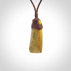 Hand carved from a lovely piece of local New Zealand Flower Jade. We have suspended this from a 3-plait brown cord which can be adjusted with a couple of slip knots and brown binding.