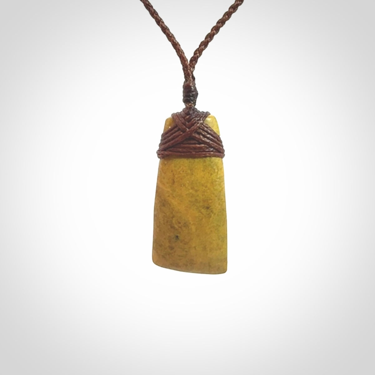 Hand carved from a lovely piece of local New Zealand Flower Jade. We have suspended this from a 3-plait brown cord which can be adjusted with a couple of slip knots and brown binding.