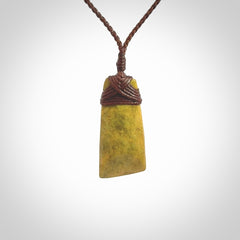 Hand carved from a lovely piece of local New Zealand Flower Jade. We have suspended this from a 3-plait brown cord which can be adjusted with a couple of slip knots and brown binding.