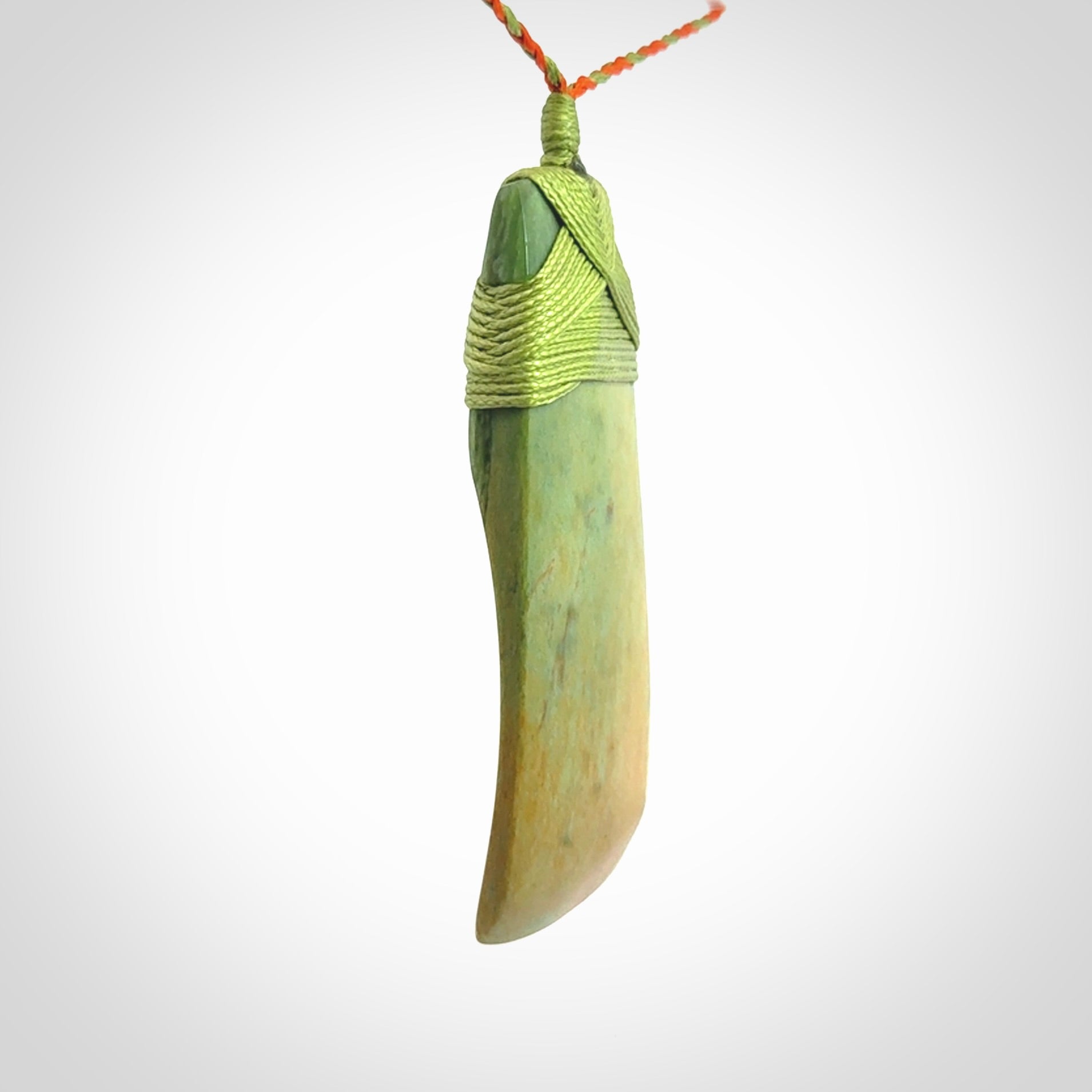 Hand carved Toki pendant from a lovely piece of local New Zealand Flower Jade. We have suspended this from a orange and green cord which can be adjusted with a couple of slip knots and green binding.