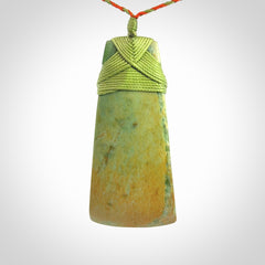 Hand carved Toki pendant from a lovely piece of local New Zealand Flower Jade. We have suspended this from a orange and green cord which can be adjusted with a couple of slip knots and green binding.
