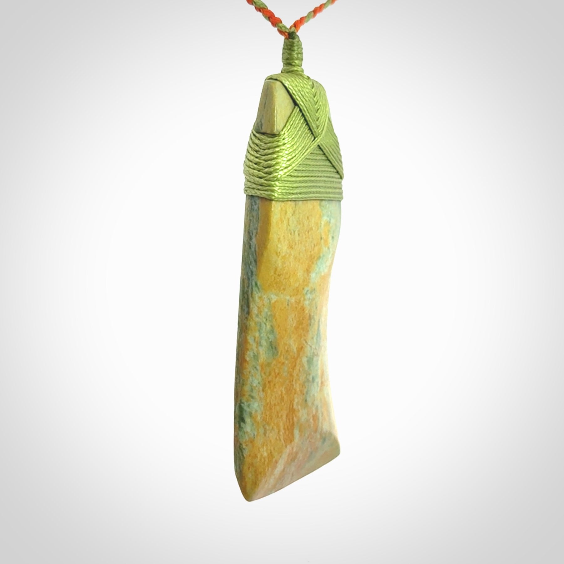 Hand carved Toki pendant from a lovely piece of local New Zealand Flower Jade. We have suspended this from a orange and green cord which can be adjusted with a couple of slip knots and green binding.