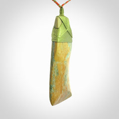 Hand carved Toki pendant from a lovely piece of local New Zealand Flower Jade. We have suspended this from a orange and green cord which can be adjusted with a couple of slip knots and green binding.
