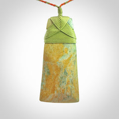 Hand carved Toki pendant from a lovely piece of local New Zealand Flower Jade. We have suspended this from a orange and green cord which can be adjusted with a couple of slip knots and green binding.