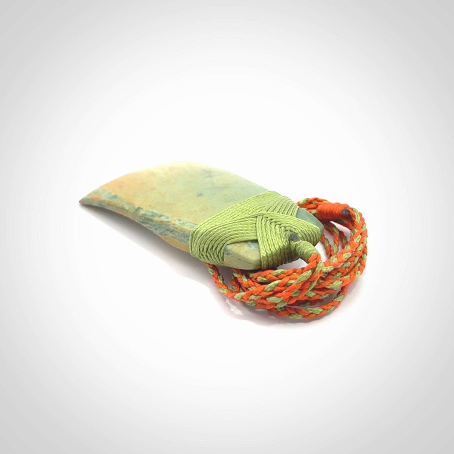 Hand carved Toki pendant from a lovely piece of local New Zealand Flower Jade. We have suspended this from a orange and green cord which can be adjusted with a couple of slip knots and green binding.