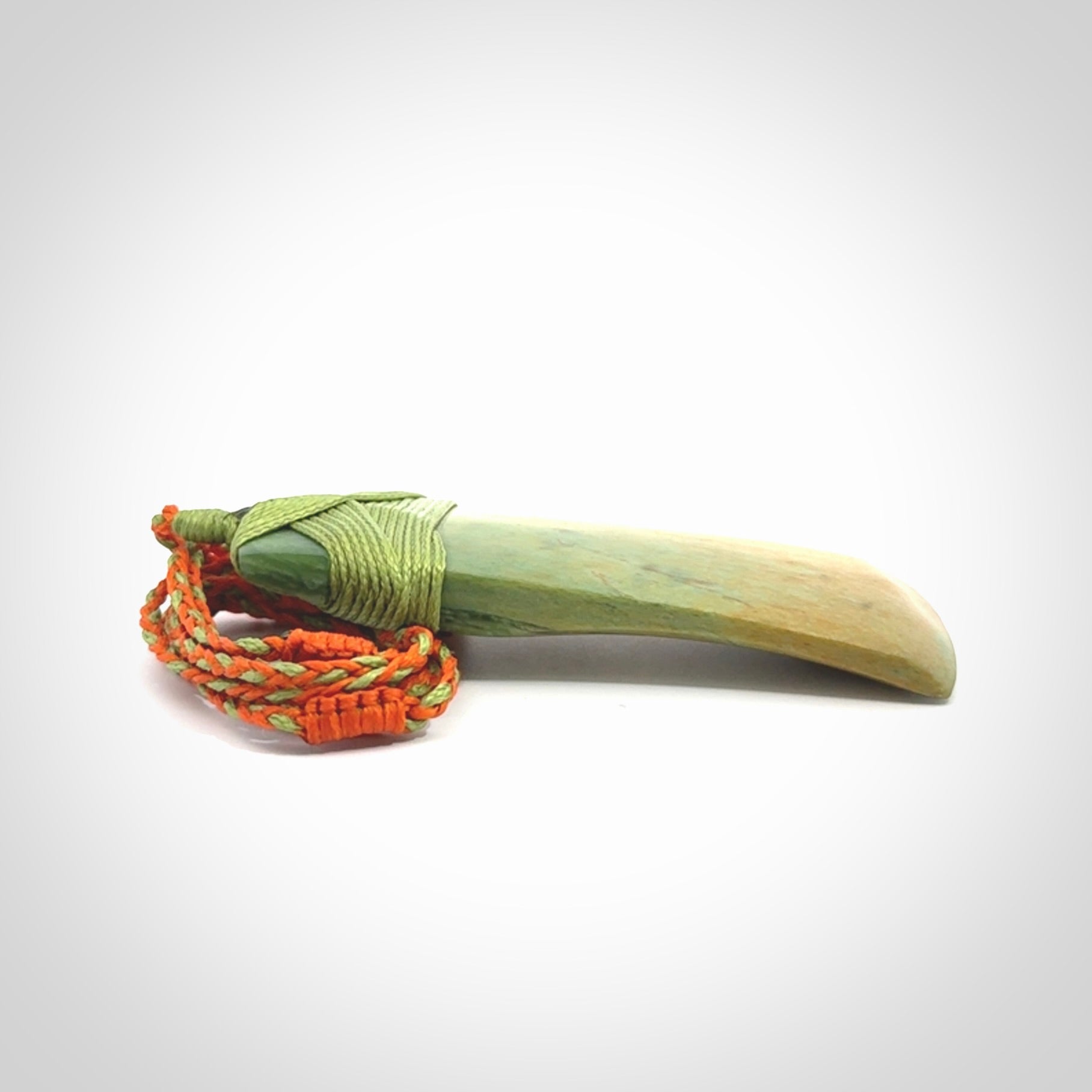 Hand carved Toki pendant from a lovely piece of local New Zealand Flower Jade. We have suspended this from a orange and green cord which can be adjusted with a couple of slip knots and green binding.