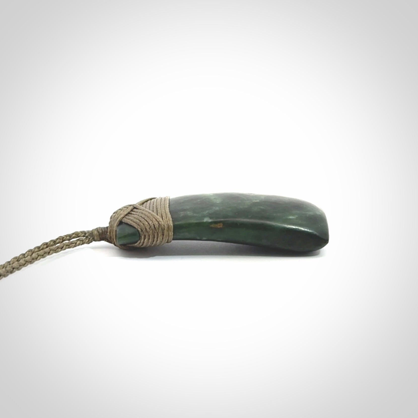 Hand carved Toki pendant from a lovely piece of local New Zealand Jade. We have suspended this from a 4-plait olive cord which can be adjusted with a couple of slip knots and olive binding.