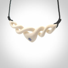 A hand carved twist pendant made from bone. This is a work of art carved by Fumio Noguchi who is renowned for his skill in bone carving. We deliver this pendant to you on a plaited black cord. Delivery with Express Courier is included in the price.