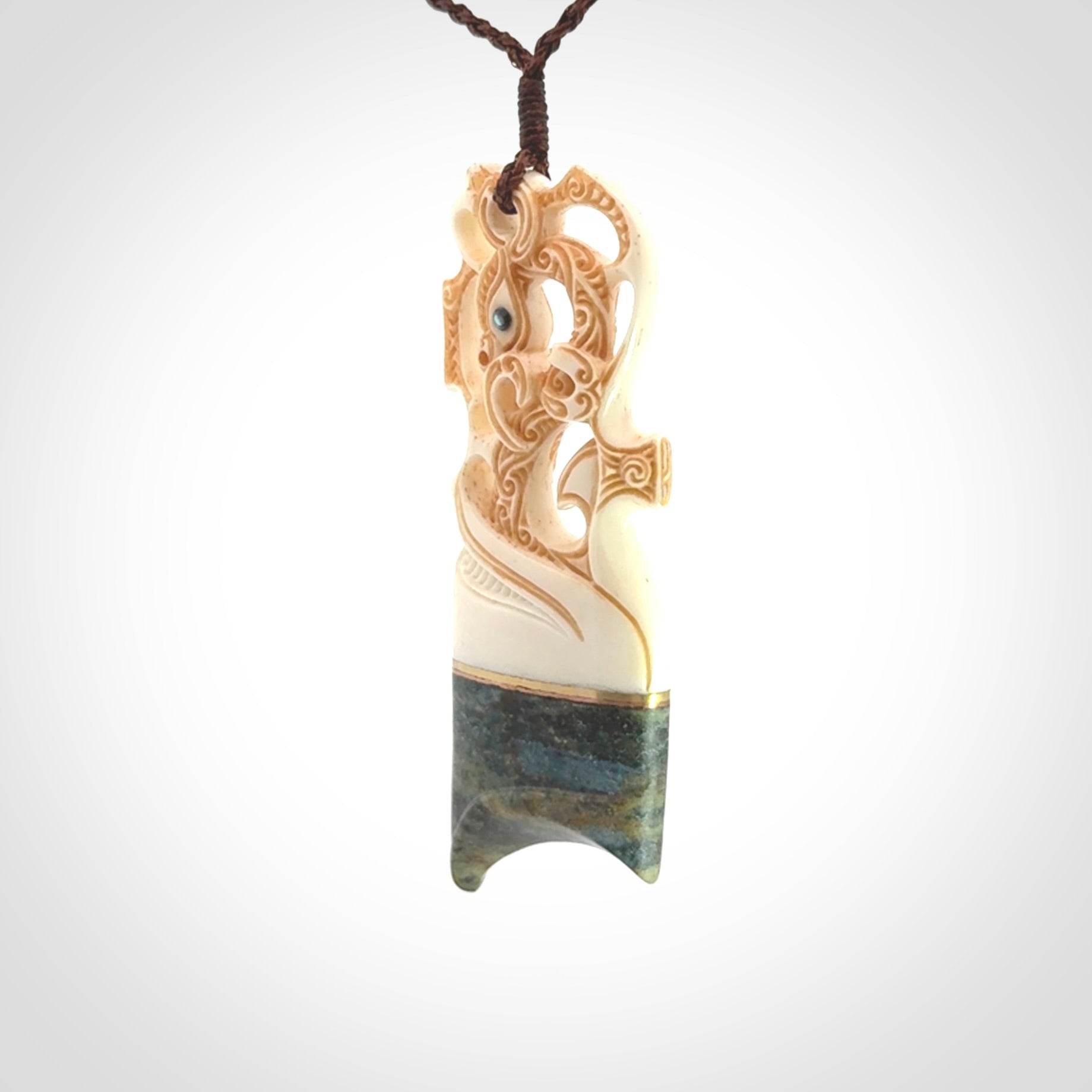 This is a large carved Manaia pendant. It is made from unique materials - New Zealand Obay Stone, Bone, Paua shell, Brass. The face of the Manaia is carved with a traditional design in the front. It is carved front and back and has traditional carved designs. This is a large and very traditional pendant that is a collectors piece.