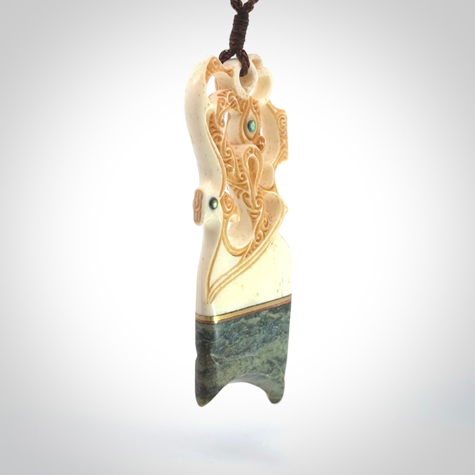 This is a large carved Manaia pendant. It is made from unique materials - New Zealand Obay Stone, Bone, Paua shell, Brass. The face of the Manaia is carved with a traditional design in the front. It is carved front and back and has traditional carved designs. This is a large and very traditional pendant that is a collectors piece.
