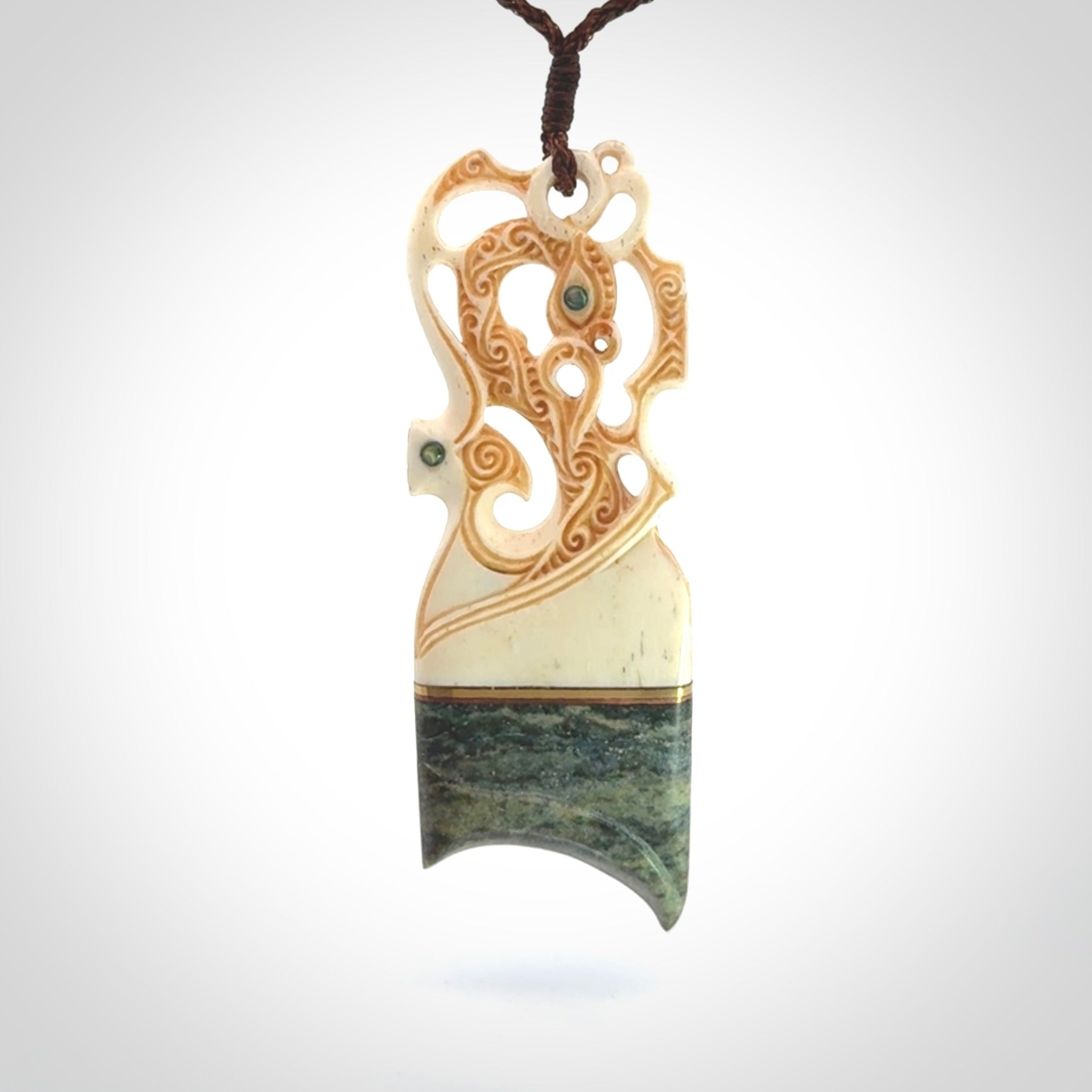 This is a large carved Manaia pendant. It is made from unique materials - New Zealand Obay Stone, Bone, Paua shell, Brass. The face of the Manaia is carved with a traditional design in the front. It is carved front and back and has traditional carved designs. This is a large and very traditional pendant that is a collectors piece.