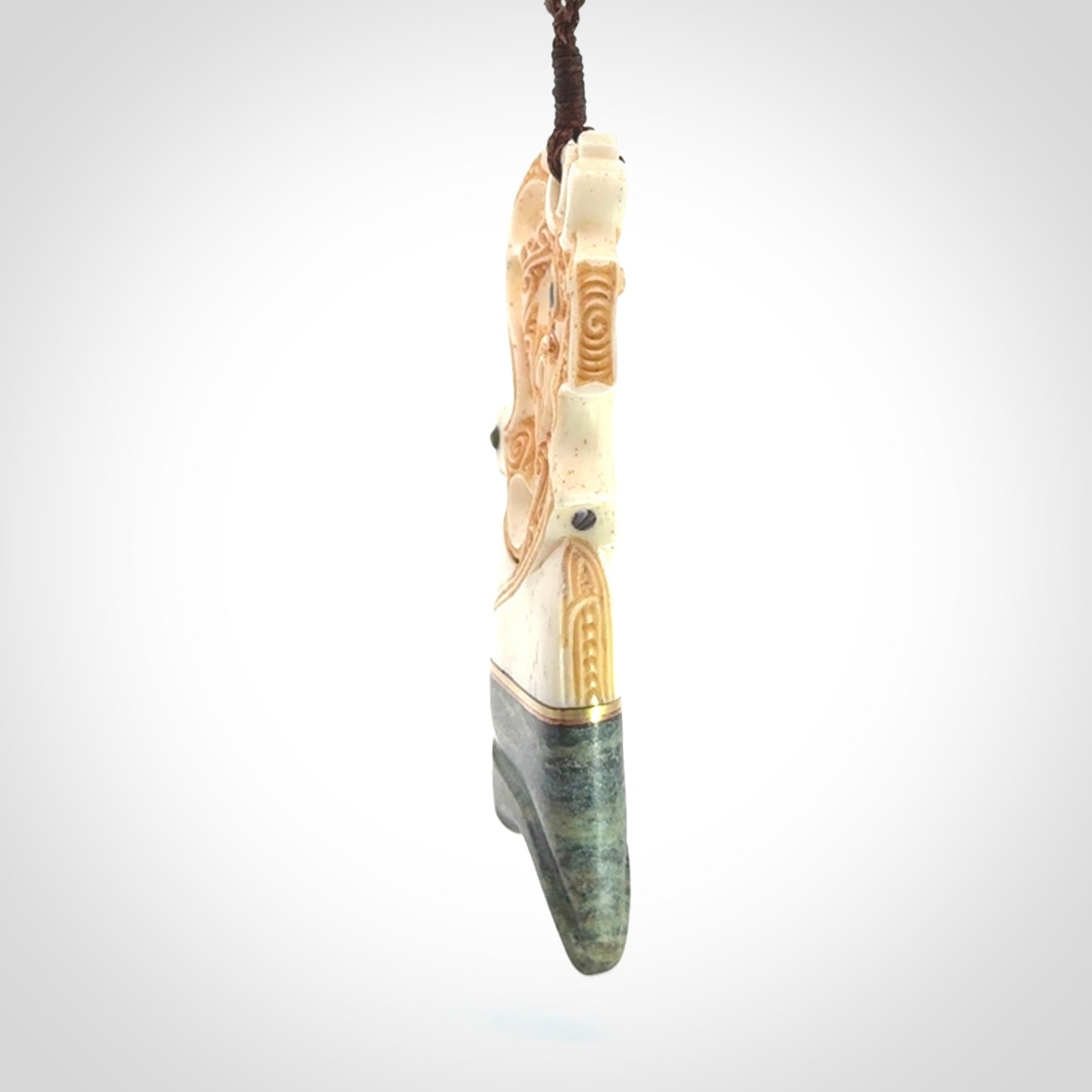 This is a large carved Manaia pendant. It is made from unique materials - New Zealand Obay Stone, Bone, Paua shell, Brass. The face of the Manaia is carved with a traditional design in the front. It is carved front and back and has traditional carved designs. This is a large and very traditional pendant that is a collectors piece.