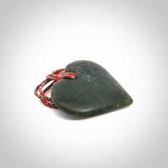 A hand carved heart pendant made from New Zealand jade.