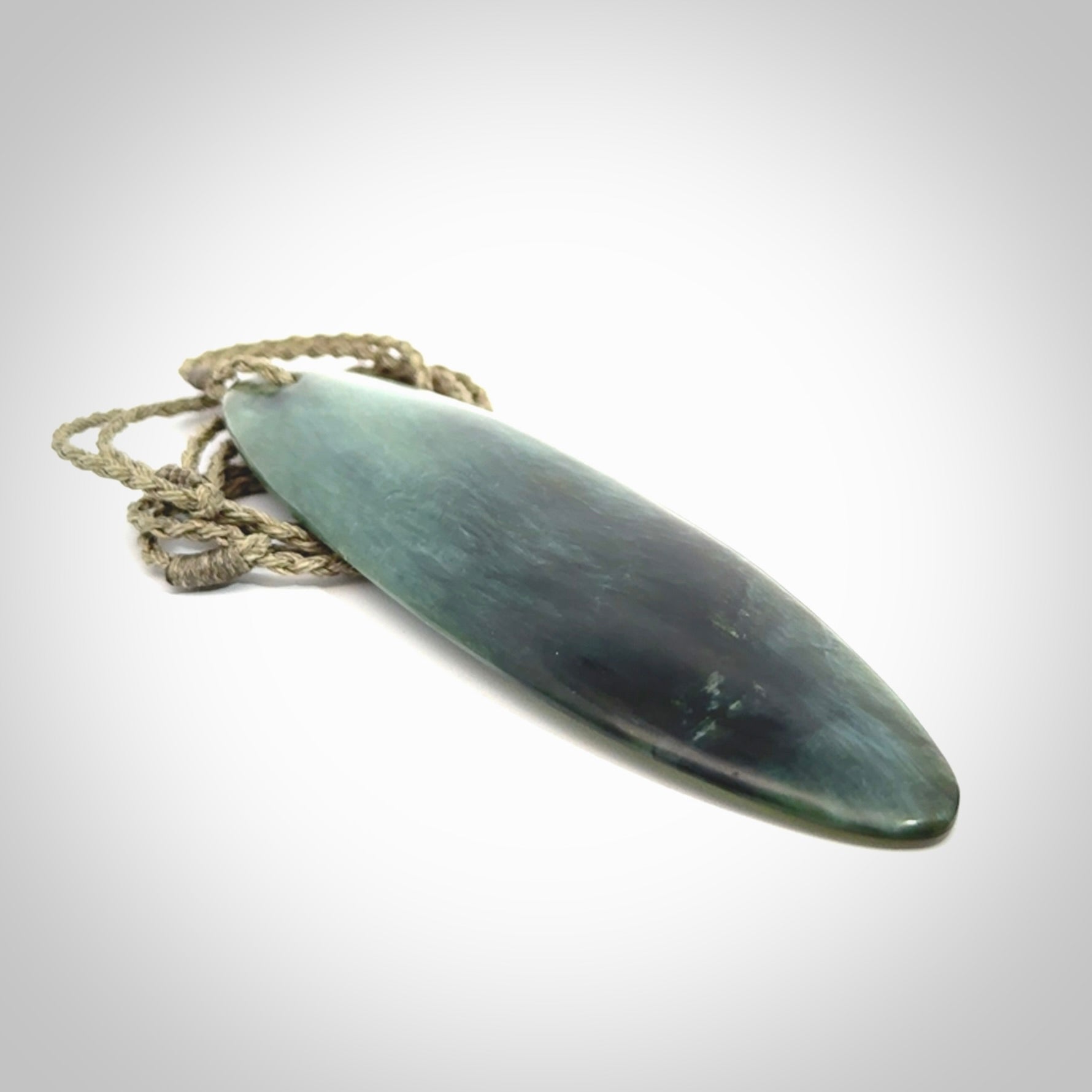 This picture shows a beautiful large sized drop pendant carved in New Zealand Tangiwai pounamu. It is a lovely chatoyant green/blue colour, which is semi-translucent when held to the light. A gorgeous and very meaningful pendant with an adjustable cord.