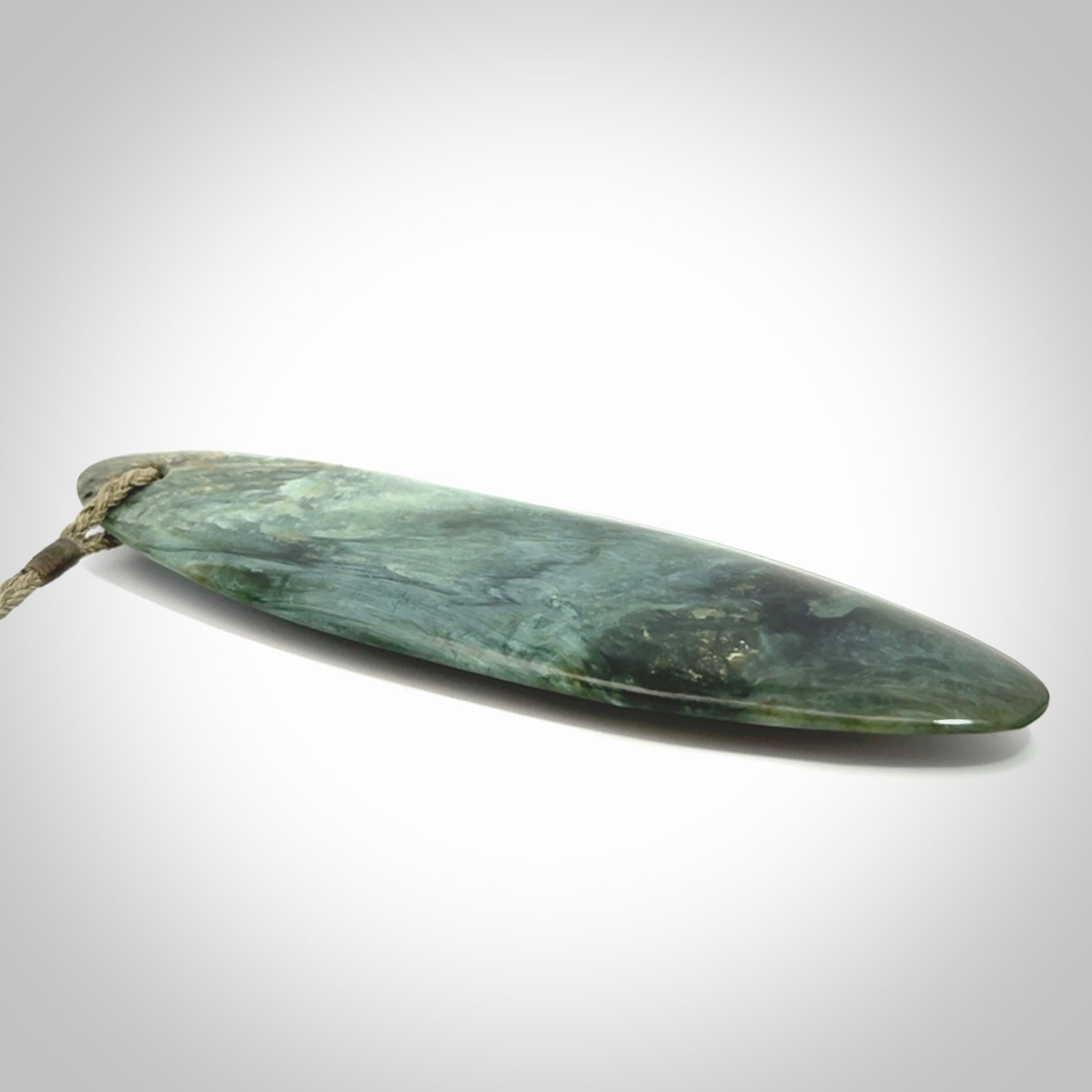 This picture shows a beautiful large sized drop pendant carved in New Zealand Tangiwai pounamu. It is a lovely chatoyant green/blue colour, which is semi-translucent when held to the light. A gorgeous and very meaningful pendant with an adjustable cord.