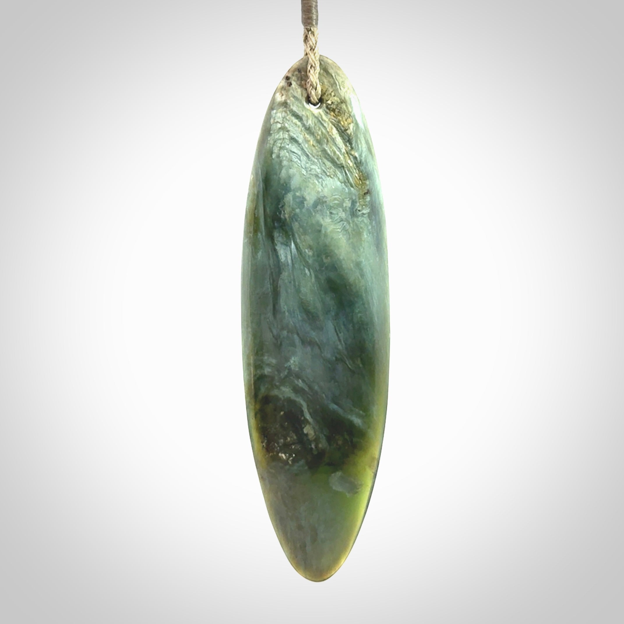 This picture shows a beautiful large sized drop pendant carved in New Zealand Tangiwai pounamu. It is a lovely chatoyant green/blue colour, which is semi-translucent when held to the light. A gorgeous and very meaningful pendant with an adjustable cord.