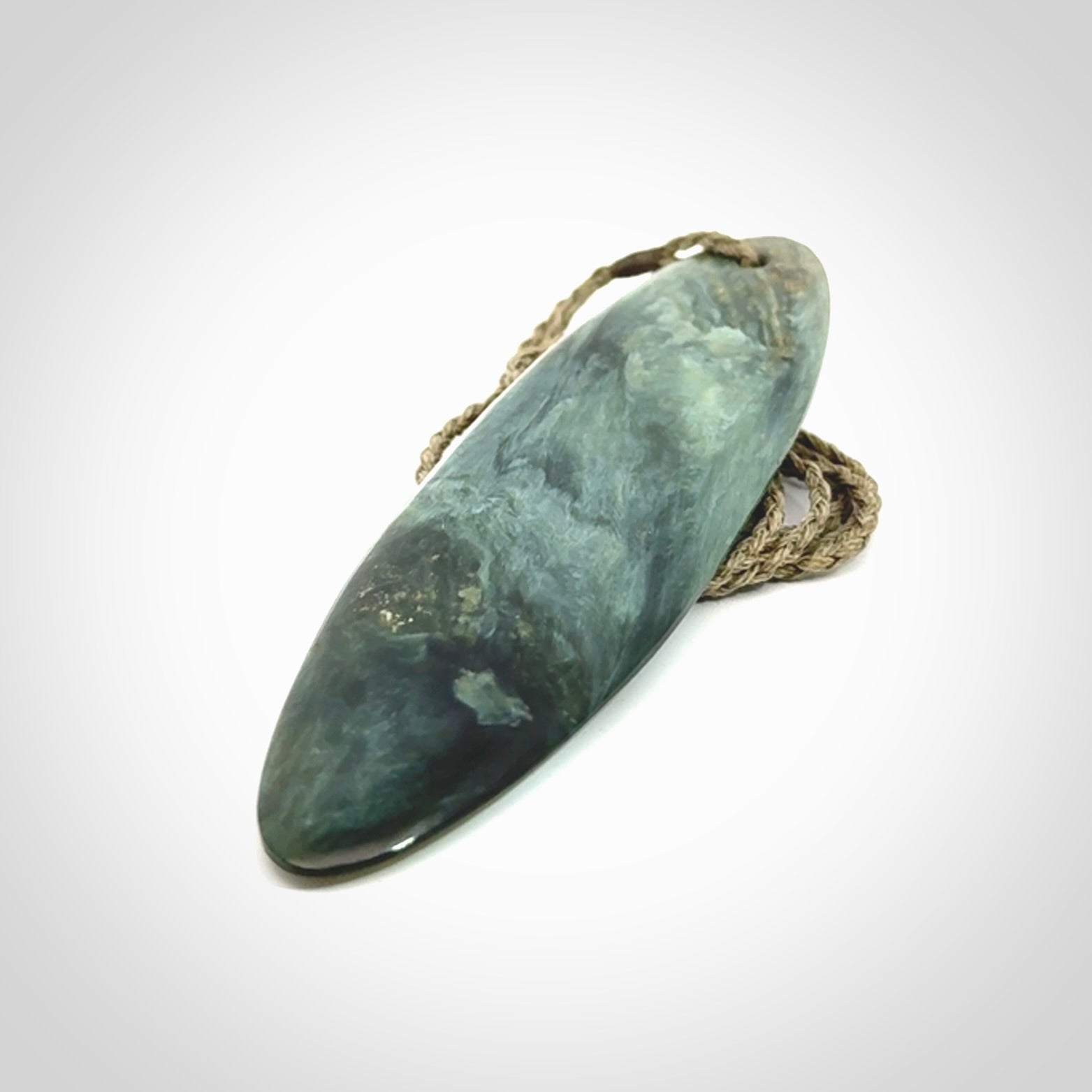 This picture shows a beautiful large sized drop pendant carved in New Zealand Tangiwai pounamu. It is a lovely chatoyant green/blue colour, which is semi-translucent when held to the light. A gorgeous and very meaningful pendant with an adjustable cord.