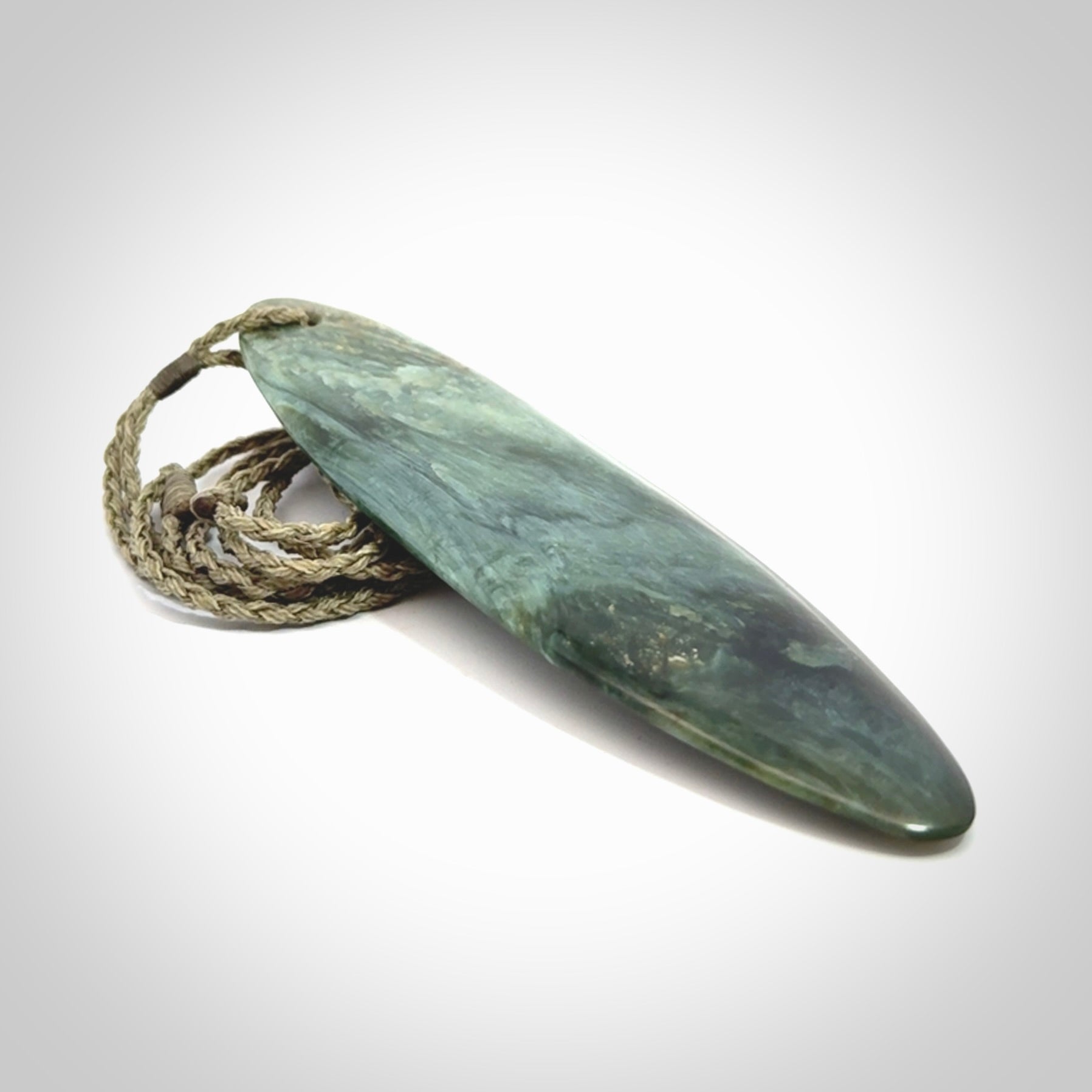 This picture shows a beautiful large sized drop pendant carved in New Zealand Tangiwai pounamu. It is a lovely chatoyant green/blue colour, which is semi-translucent when held to the light. A gorgeous and very meaningful pendant with an adjustable cord.