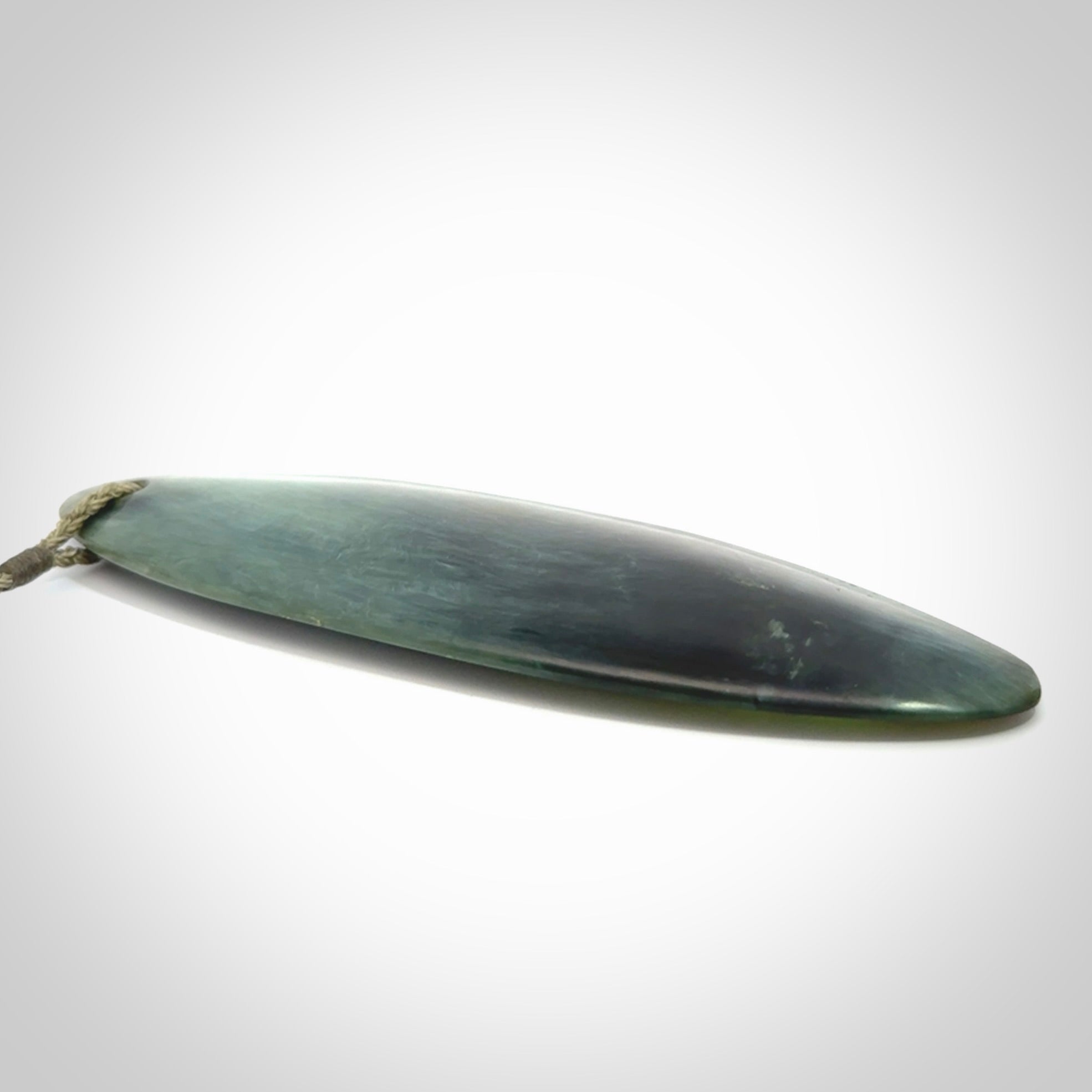 This picture shows a beautiful large sized drop pendant carved in New Zealand Tangiwai pounamu. It is a lovely chatoyant green/blue colour, which is semi-translucent when held to the light. A gorgeous and very meaningful pendant with an adjustable cord.