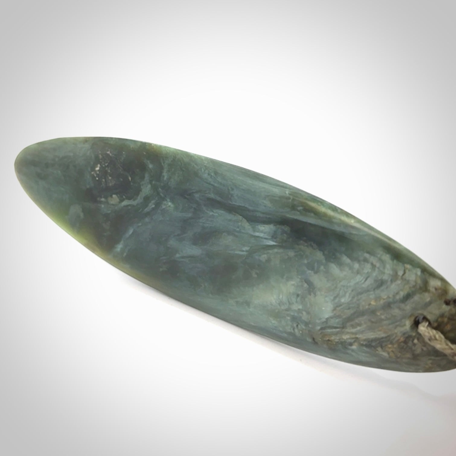 This picture shows a beautiful large sized drop pendant carved in New Zealand Tangiwai pounamu. It is a lovely chatoyant green/blue colour, which is semi-translucent when held to the light. A gorgeous and very meaningful pendant with an adjustable cord.