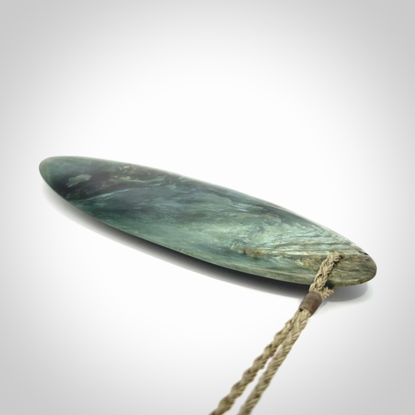 This picture shows a beautiful large sized drop pendant carved in New Zealand Tangiwai pounamu. It is a lovely chatoyant green/blue colour, which is semi-translucent when held to the light. A gorgeous and very meaningful pendant with an adjustable cord.