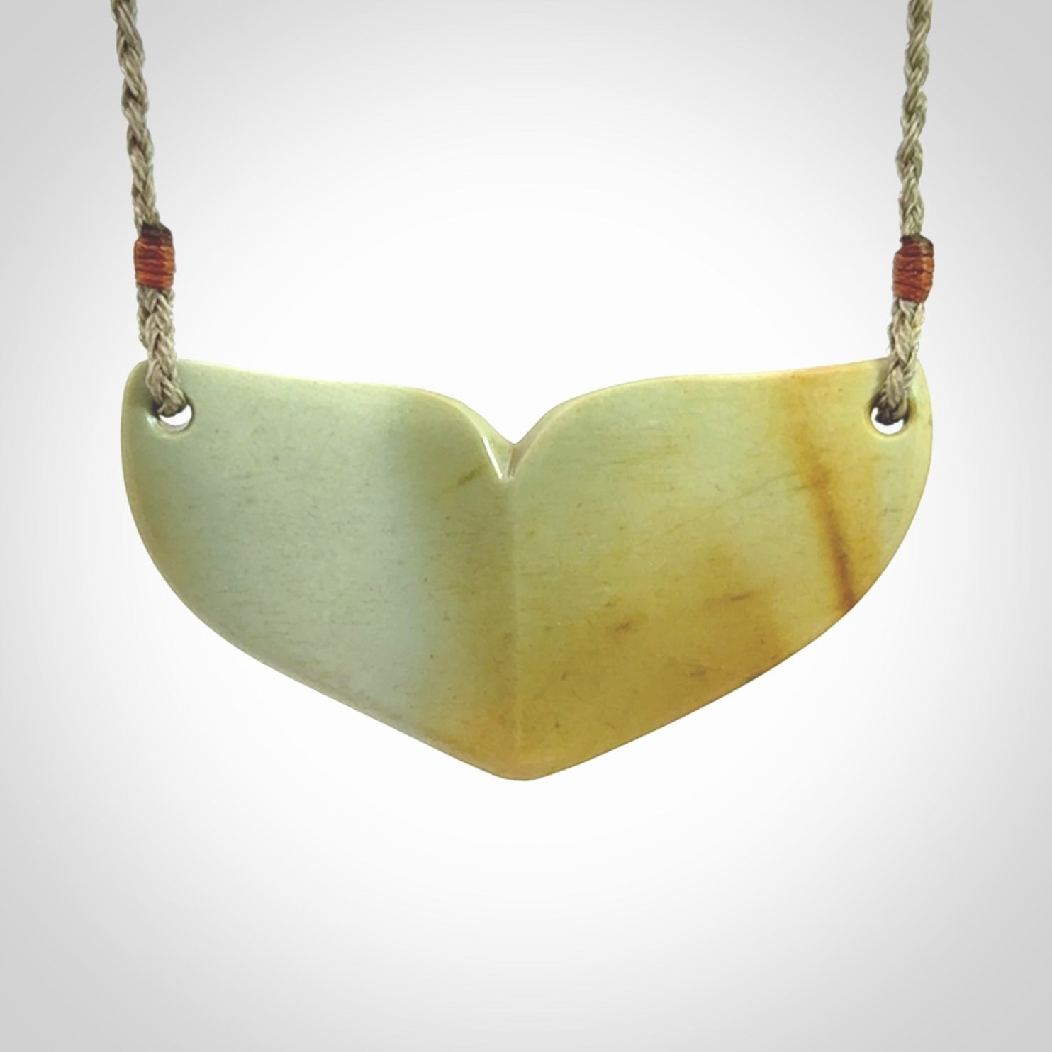 Hand carved New Zealand Flower Jade whale tail pendant.