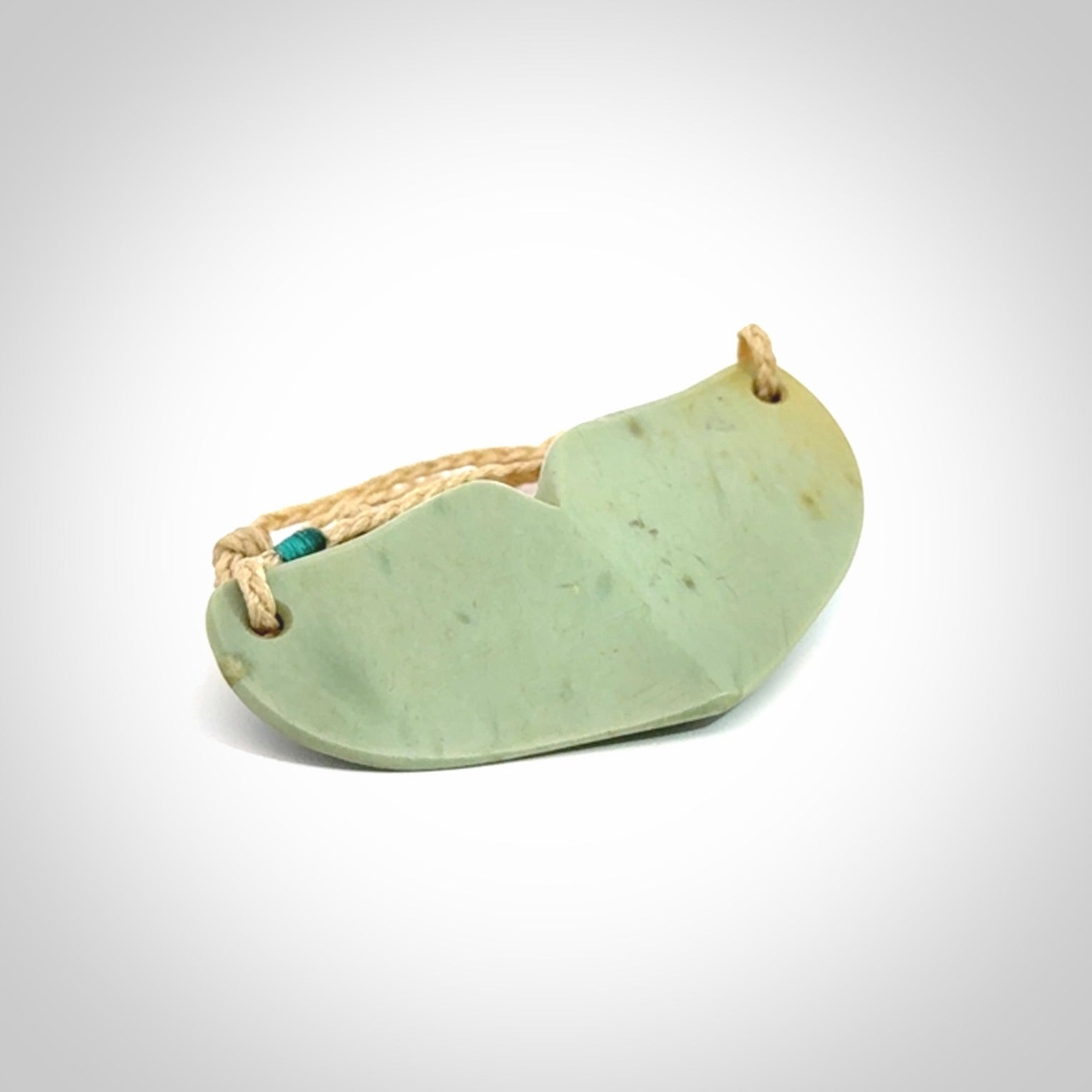 Hand carved New Zealand Flower Jade whale tail pendant.