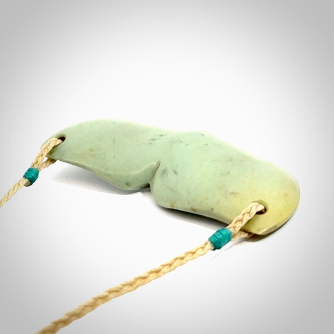 Hand carved New Zealand Flower Jade whale tail pendant.