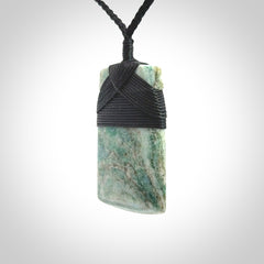 This is a handcrafted aotea stone Toki pendant.