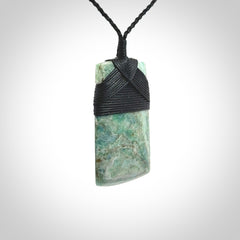 This is a handcrafted aotea stone Toki pendant.