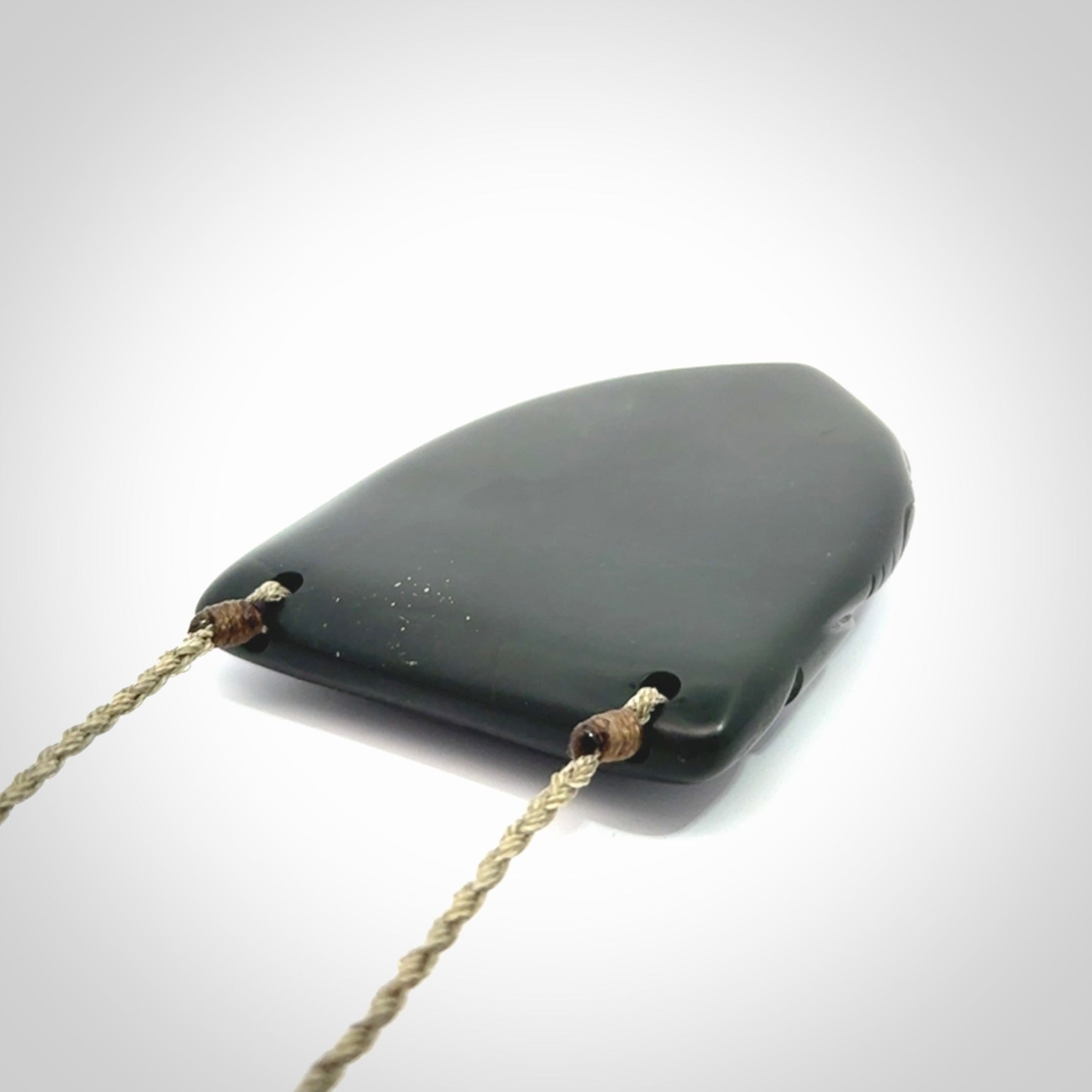This is a hand carved New Zealand Jade wheku pendant. It is made from New Zealand Jade and Paua shell.