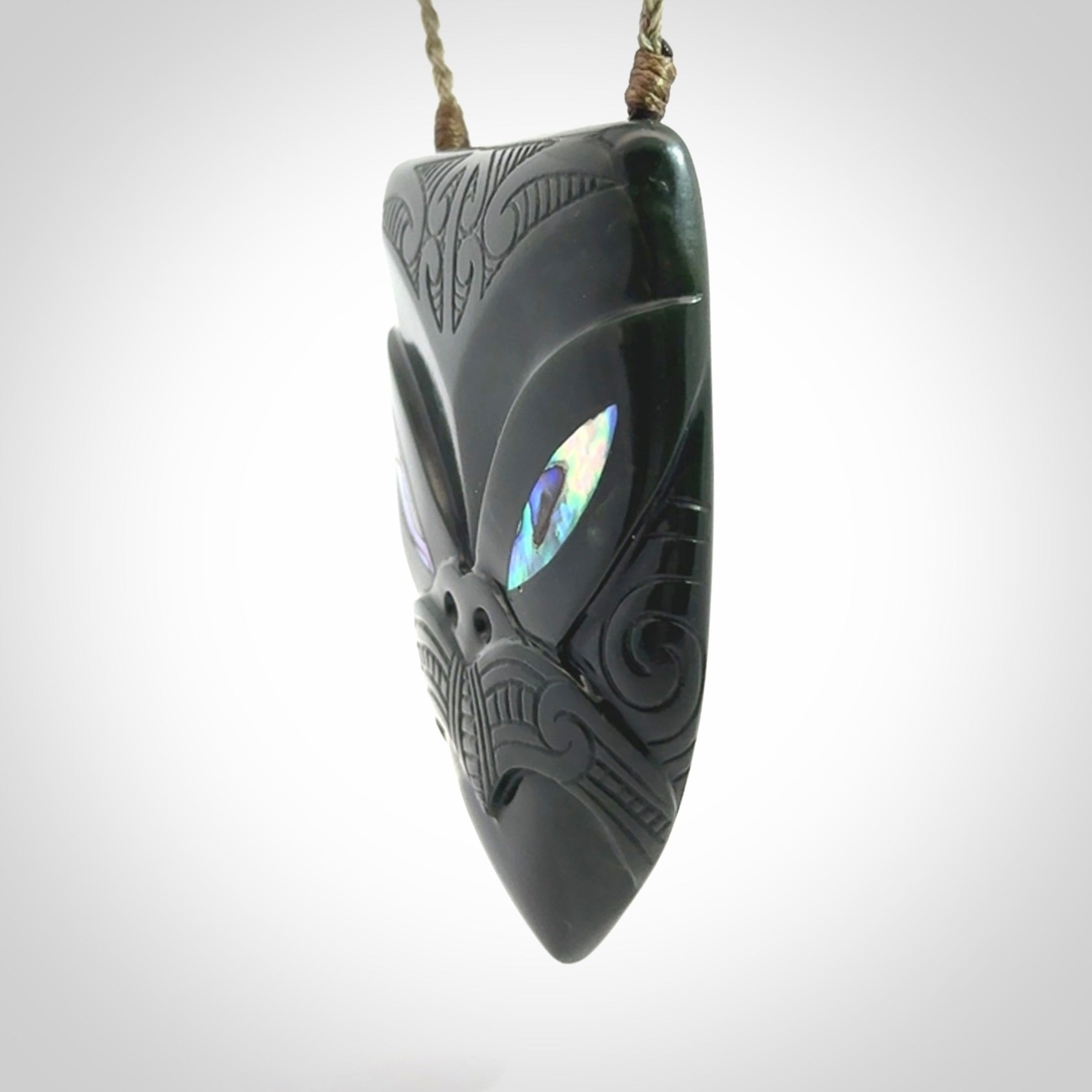 This is a hand carved New Zealand Jade wheku pendant. It is made from New Zealand Jade and Paua shell.