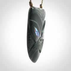 This is a hand carved New Zealand Jade wheku pendant. It is made from New Zealand Jade and Paua shell.