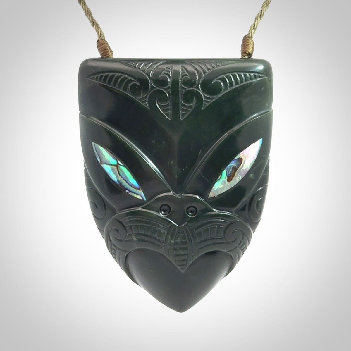 This is a hand carved New Zealand Jade wheku pendant. It is made from New Zealand Jade and Paua shell.