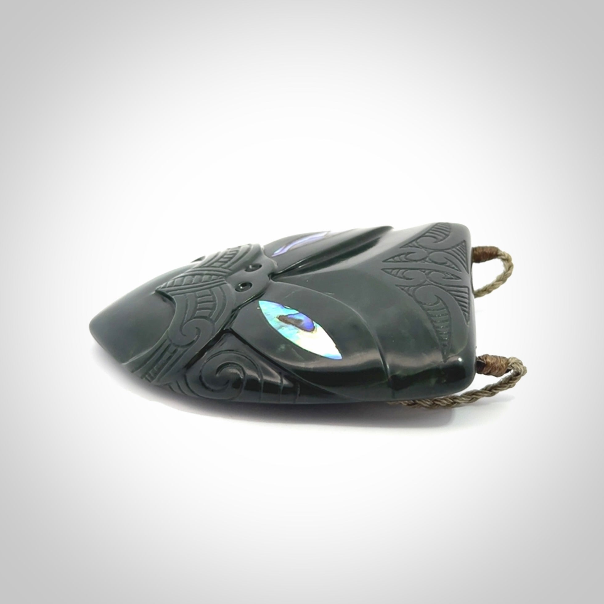 This is a hand carved New Zealand Jade wheku pendant. It is made from New Zealand Jade and Paua shell.