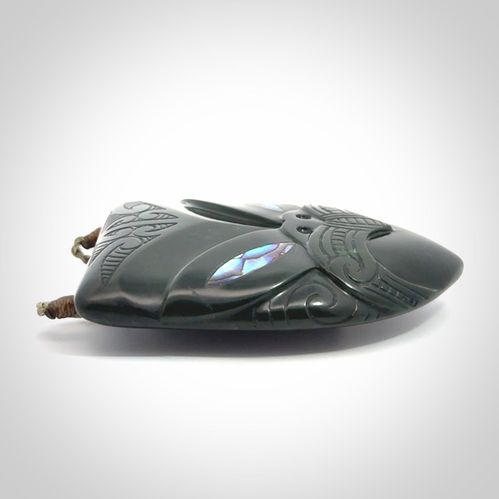 This is a hand carved New Zealand Jade wheku pendant. It is made from New Zealand Jade and Paua shell.
