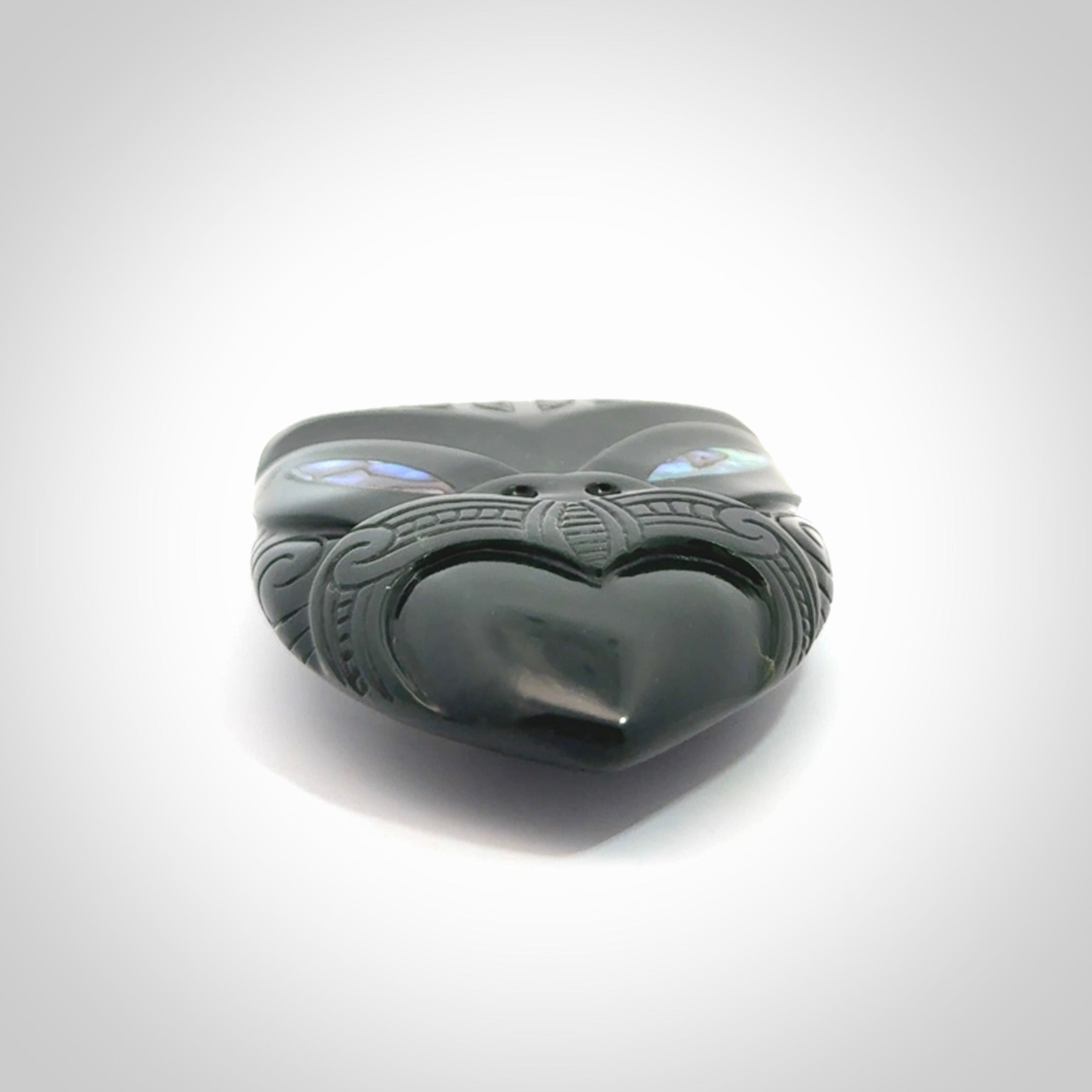 This is a hand carved New Zealand Jade wheku pendant. It is made from New Zealand Jade and Paua shell.