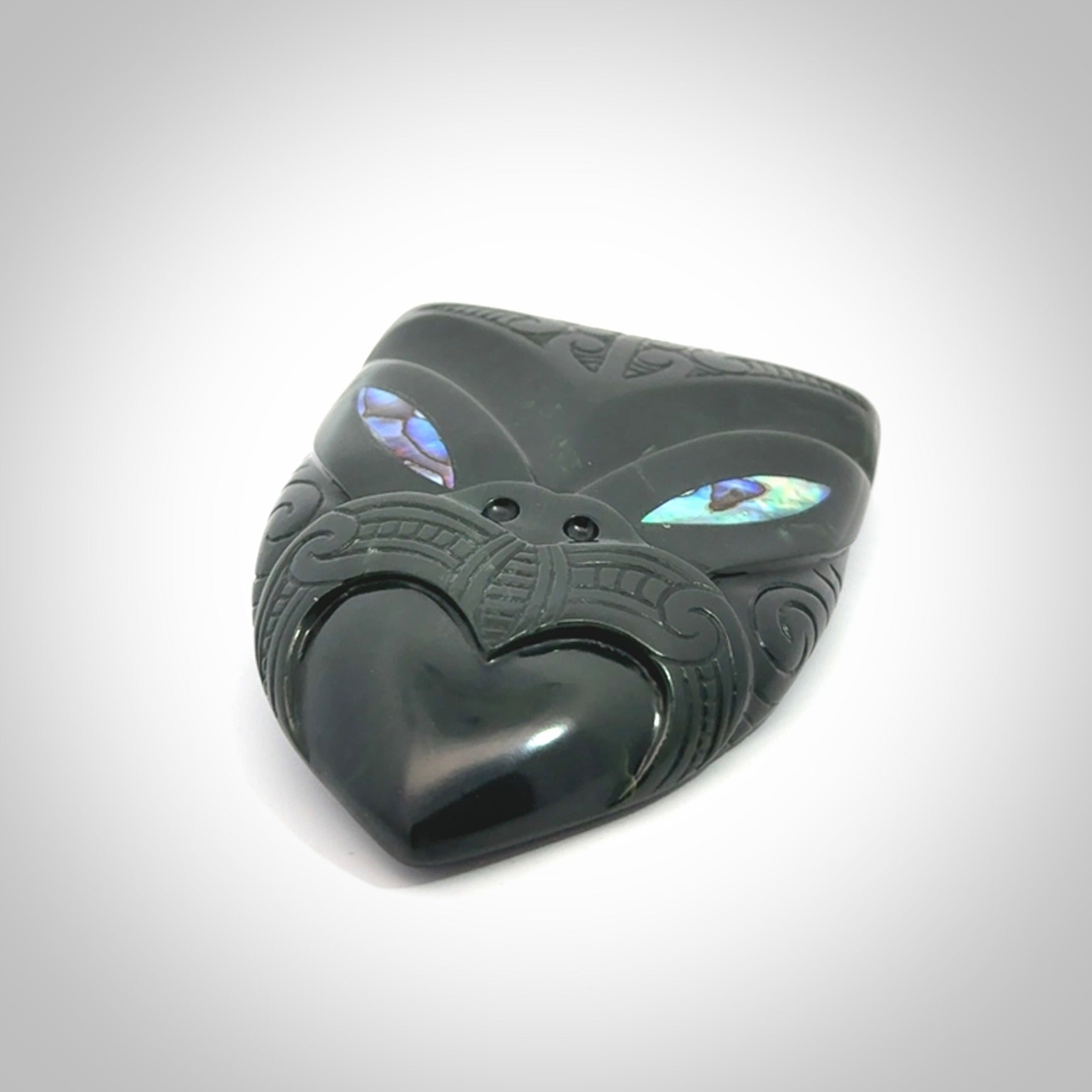 This is a hand carved New Zealand Jade wheku pendant. It is made from New Zealand Jade and Paua shell.