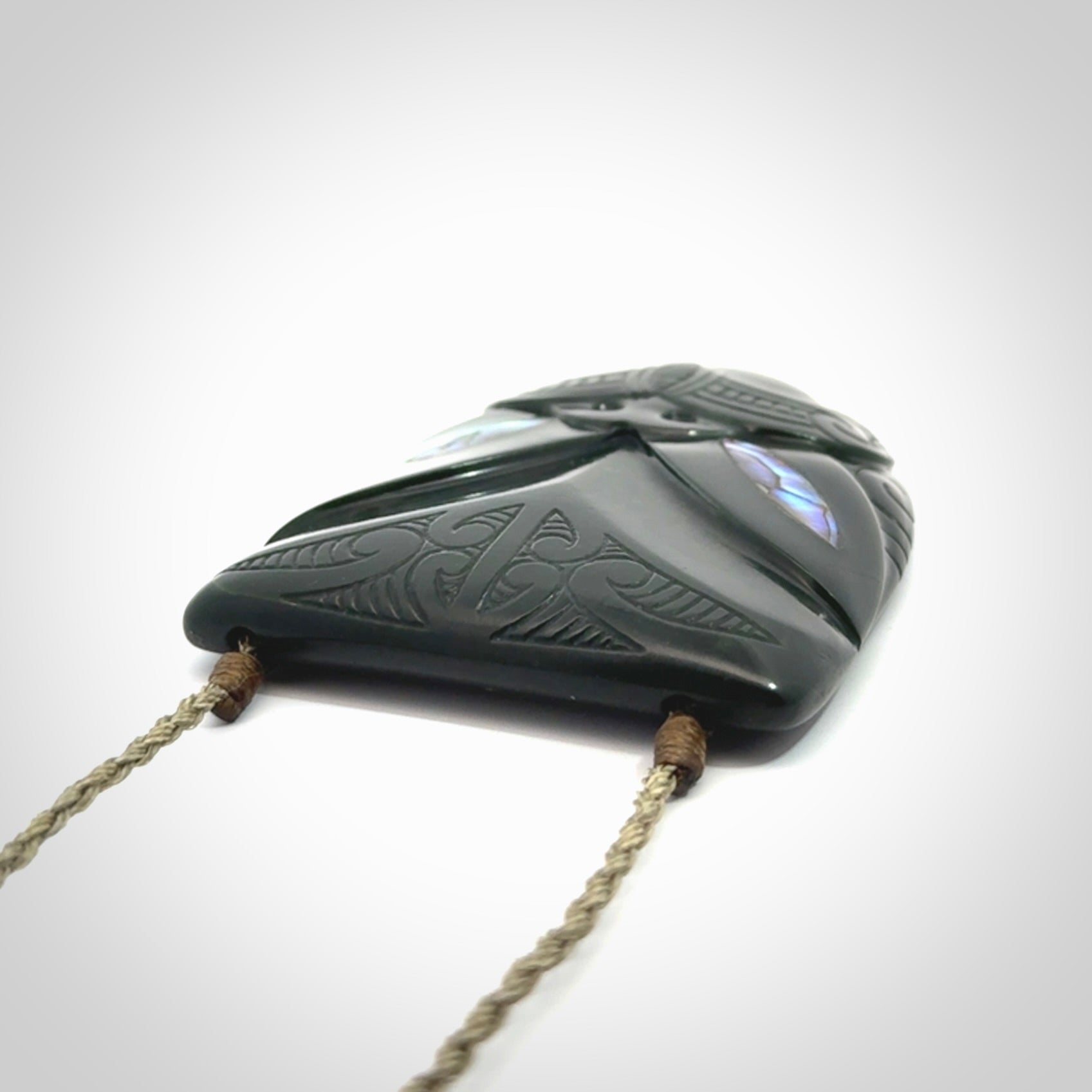 This is a hand carved New Zealand Jade wheku pendant. It is made from New Zealand Jade and Paua shell.