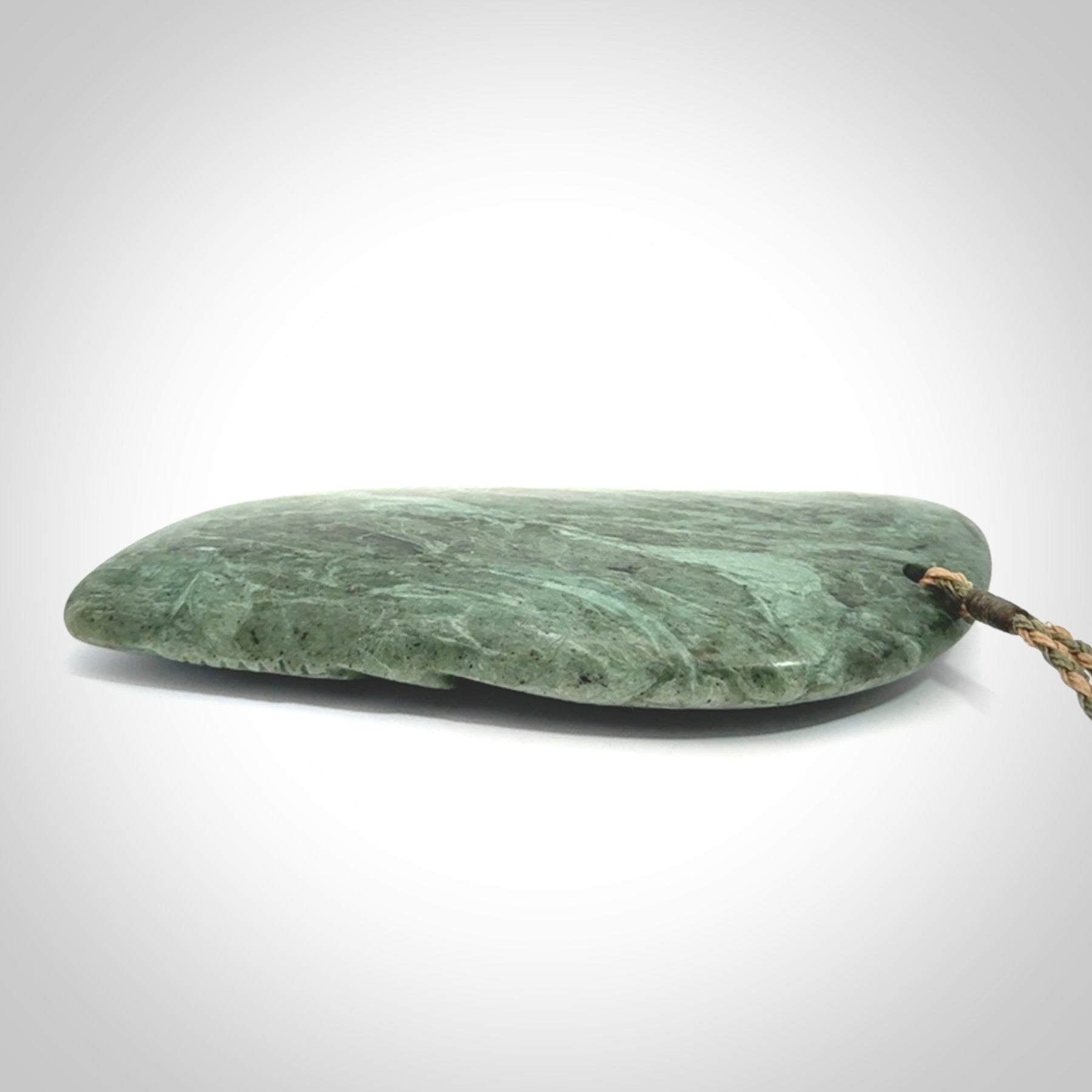 This is a hand carved New Zealand Jade wheku pendant. It is made from New Zealand Jade and Paua shell.
